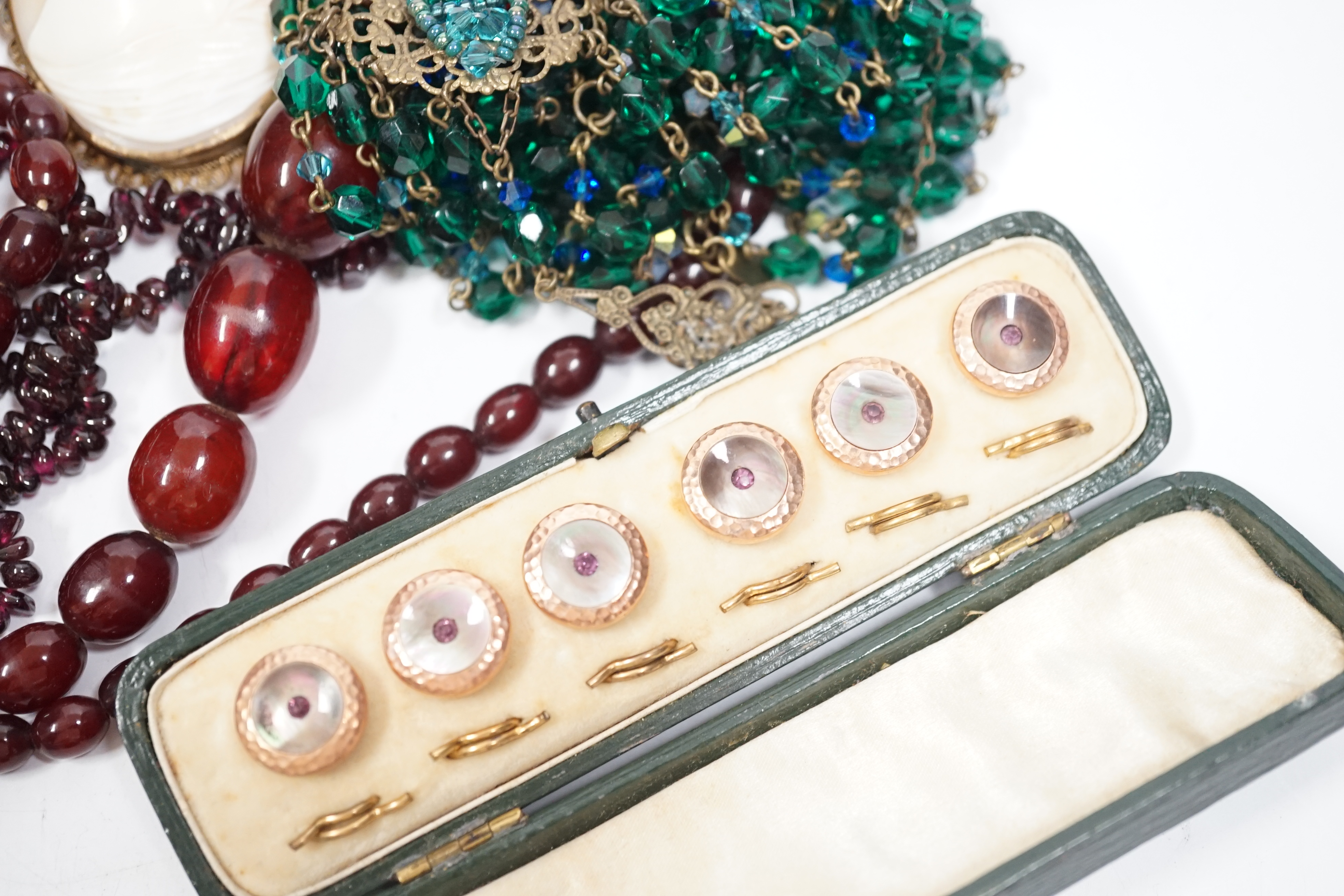 A group of assorted costume and other jewellery including a simulated cherry amber necklace, 52cm, gross weight 33 grams, a gilt metal and mother of pearl dress stud set, pair of Ruskin ceramic cufflinks, A Victorian sil